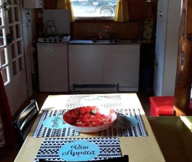 Intérieur de cabane en bois avec table et cuisine dans la Cabane randonneur au camping