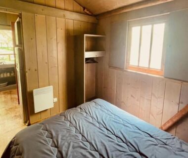Chambre en bois avec lit et fenêtre dans la Cabane sur pilotis avec terrasse au calme - API-1-52-1502