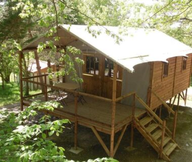 Terrasse sur pilotis en bois entourée d'arbres de la Cabane sur pilotis avec terrasse au calme API-1-52-1502