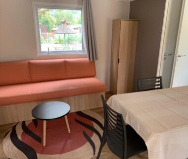 Salon avec canapé et table dans le mobil-home Calme & Sérénité