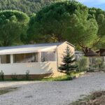 Mobil-home devant pins et chemin au camping Calme & Sérénité