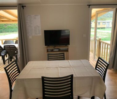 Séjour avec table et télévision dans le mobil home du Calme & Sérénité