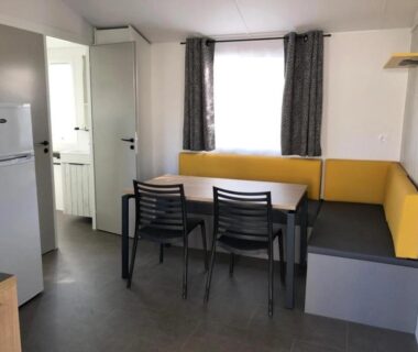 Coin repas banquette jaune dans le mobil-home du Camping 3 étoiles 1km de la plage Piscine chauffée et Espace Fitness