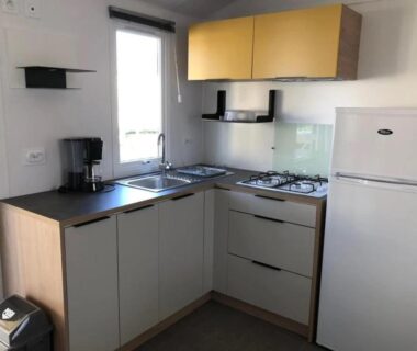 Kitchenette avec réfrigérateur et plaques dans le mobil-home du Camping 3 étoiles 1km plage Piscine chauffée Espace Fitness