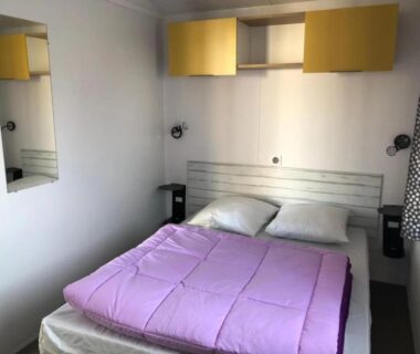 Chambre avec lit double et rangements dans le Camping 3 étoiles 1km de la plage Piscine chauffée et Espace Fitness