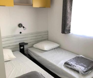Chambre avec deux lits simples et fenêtre du Camping 3 étoiles 1km de la plage Piscine chauffée et Espace Fitness