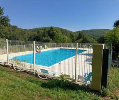 Piscine extérieure clôturée au milieu de la verdure du Camping 3 étoiles – Piscine – ccbfeb0