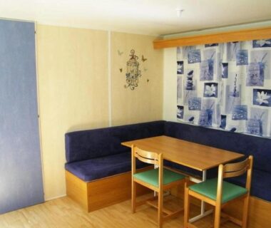Coin repas avec banquette bleue et table dans le mobil-home du Camping 3 étoiles - Piscine - ccbfeb0