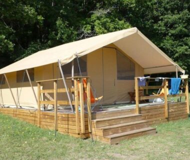Terrasse en bois devant tente lodge dans la verdure du Camping 3 étoiles Piscine chauffée Périgord Vert