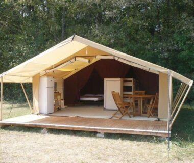 Terrasse avec tente safari équipée d'une kitchenette et table au Camping 3 étoiles Piscine chauffée Périgord Vert