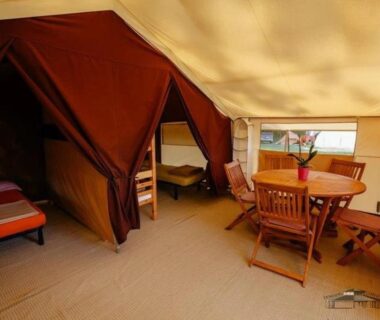 Intérieur de tente avec table et lits au Camping 3 étoiles Piscine chauffée Périgord Vert