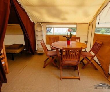 Intérieur de tente avec table et chaises dans le Camping 3 étoiles - Piscine chauffée - Périgord Vert