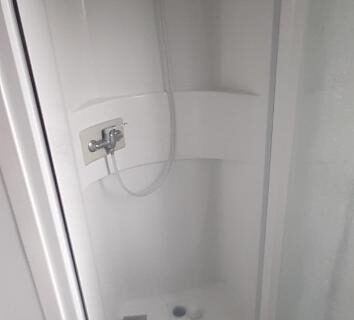Cabine de douche blanche dans la salle de bains du Camping 4* 3 CH 2 SDB Lave linge Lave vaisselle