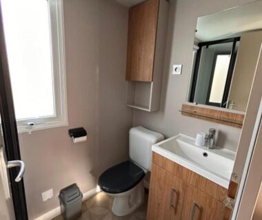 Salle de bain avec toilettes et lavabo dans le Camping 4 étoiles Mobil-Home Haut de Gamme Neuf 6-8 pers