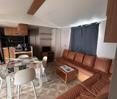 Salon avec canapé et coin repas dans le Mobil-Home Haut de Gamme Neuf 6-8 pers