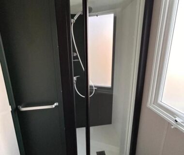 Salle de douche avec cabine vitrée et fenêtre dans le Camping 4 étoiles Mobil-Home Haut de Gamme Neuf 6-8 pers