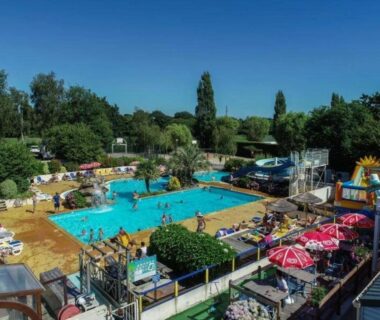 Piscine extérieure avec toboggans et parasols au Camping 4 étoiles - Parc aquatique - ccbbiei