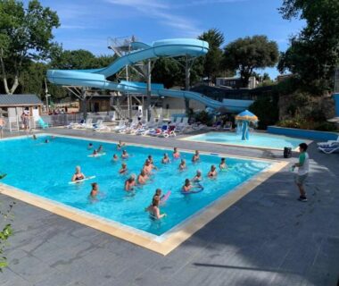 Piscine extérieure avec toboggan et baigneurs au Camping 4 étoiles ccaaeah