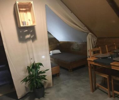 Chambre mansardée avec lit et coin repas du Camping 4 étoiles – Piscine – ccaaeah