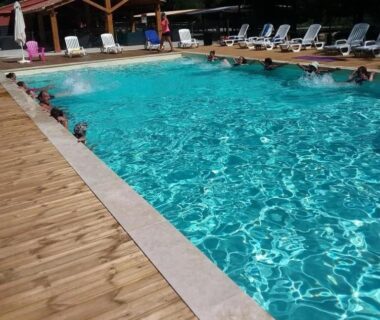 Piscine avec transats et terrasse en bois au camping ccbbihi