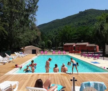 Piscine extérieure entourée d'arbres et transats au Camping 4 étoiles - Piscine - ccbbihi