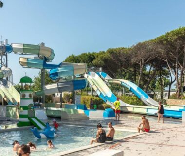 Piscine avec toboggans et baigneurs au Camping 4 étoiles à Sète
