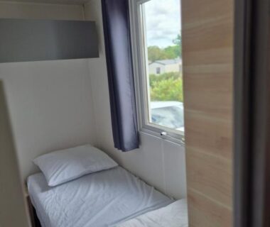 Intérieur chambre avec lit simple dans le mobil-home du Camping 4 etoiles les viviers lege cap ferret