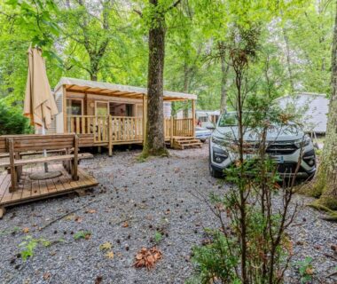 Emplacement ombragé avec mobil-homes terrasse et voiture au Camping 4 étoiles parc aquatique