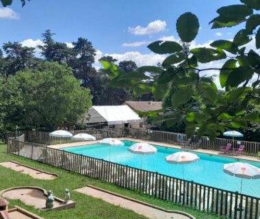 Piscine extérieure avec parasols et pelouse au Camping 46 Rainettes