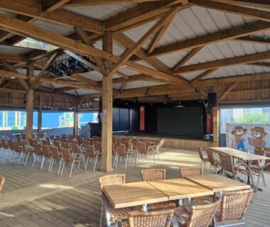Salle couverte avec tables et scène dans le Camping 5 étoiles piscines chauffées club enfants mobilhome premium 6pers