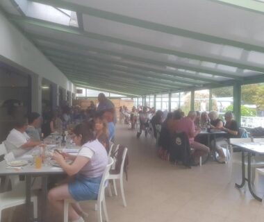 Terrasse couverte avec convives et tables au Camping A l'Abri de l'Océan