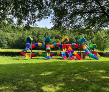 Pelouse avec structure gonflable et toboggans au camping A l'Ombre des Tilleuls