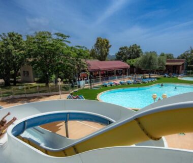 Piscine extérieure avec toboggans et transats au Camping Acqua E Sole
