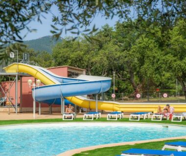 Piscine extérieure avec toboggan et transats au Camping Acqua E Sole
