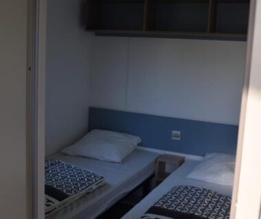 Chambre étroite avec deux lits simples au Camping Adults Only La Croix Badeau