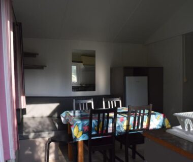 Intérieur de mobil-home avec table et chaises dans le Camping Adults Only La Croix Badeau