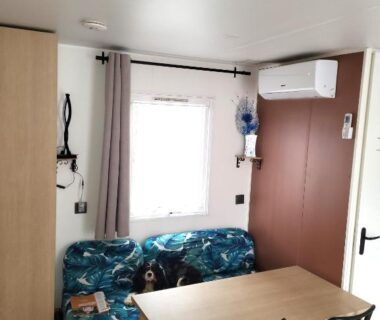 Intérieur salon avec banquette table et climatisation dans le Camping Agde Mobil home 4 places climatisé