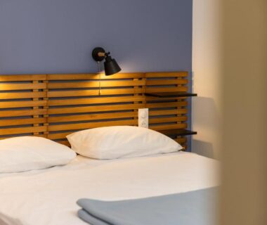 Chambre avec lit double et tête de lit en bois au Camping Alpes Dauphiné