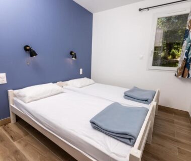 Chambre double avec lit et serviettes pliées au Camping Alpes Dauphiné