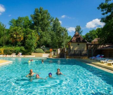 Piscine extérieure avec baigneurs et chaises longues au Camping Aqua Viva