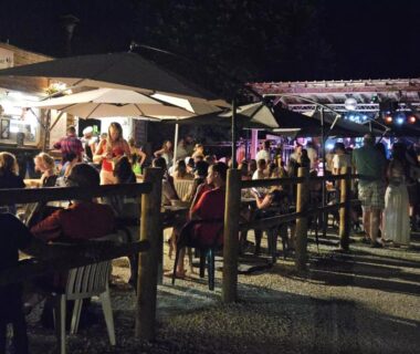 Terrasse extérieure animée avec tables et convives au Camping Aqua Viva