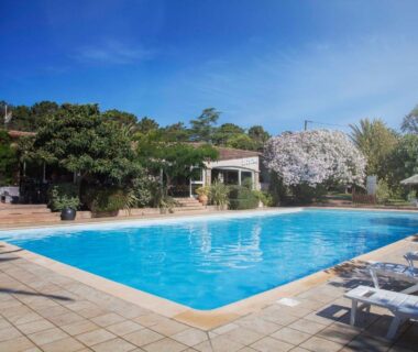 Piscine extérieure avec transats et végétation au Camping Arutoli