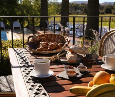Terrasse avec croissants café et jus face à la piscine du Camping Arutoli