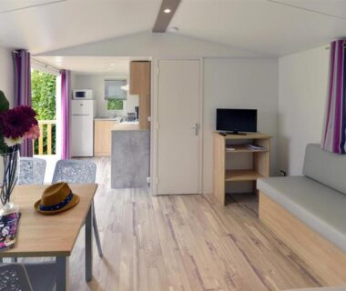 Intérieur de mobil home avec salon table et kitchenette au Camping Au Coeur de Vendome