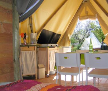 Intérieur de tente avec kitchenette et coin repas du Camping Au Lac d'Hautibus