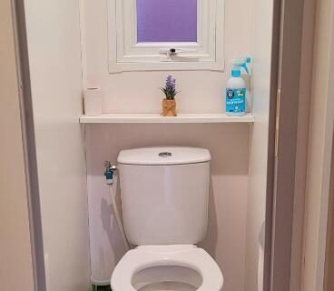 Toilettes avec fenêtre et étagère dans le Camping Aux Portes De Cassis