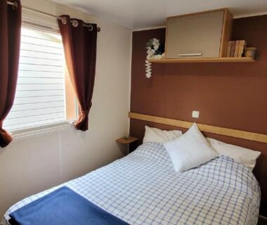 Chambre double avec lit rideaux et fenêtre au Camping Aux Portes De Cassis