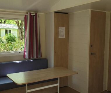 Intérieur de mobil-home avec banquette et table au camping Les Foulons
