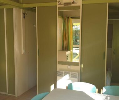 Intérieur de mobil-home avec kitchenette et coin repas au camping Les Foulons