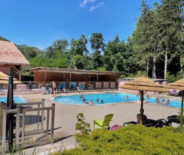 À Tournon-sur-Rhône piscine extérieure avec parasols au camping Les Foulons
